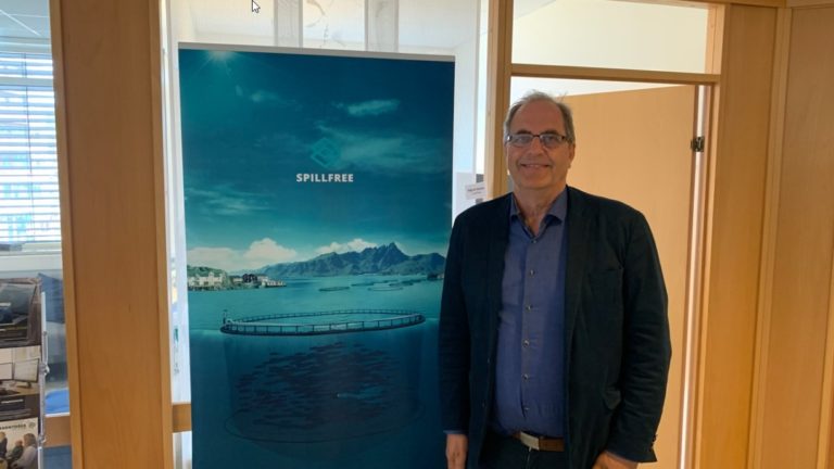 Mann som smiler i kontorlokaler. Foto