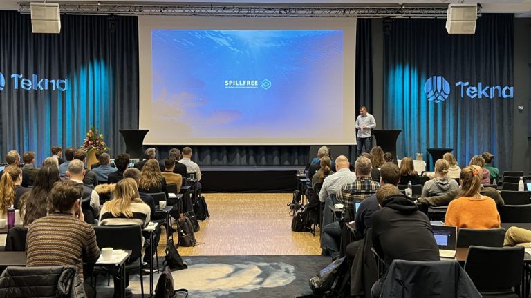 Sal med tilhørere på foran lerret. Foto