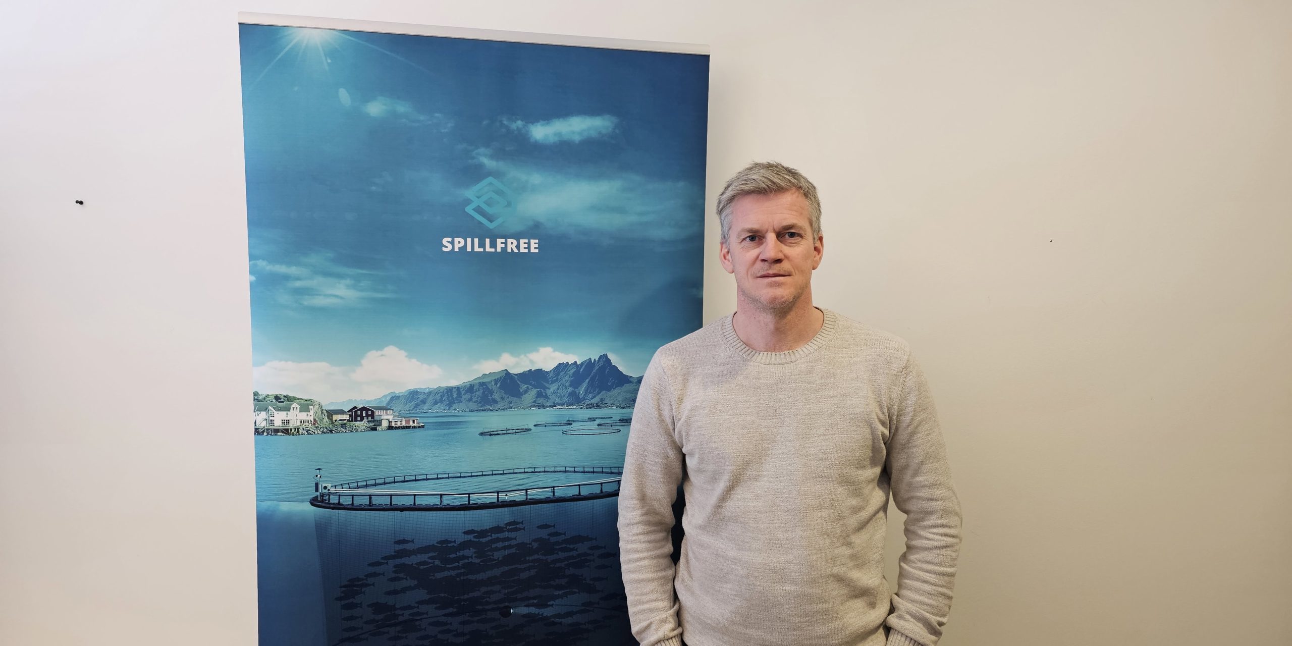 Spillfree-Kåre-Gruven Mann som smiler foran reklameplakat. Foto