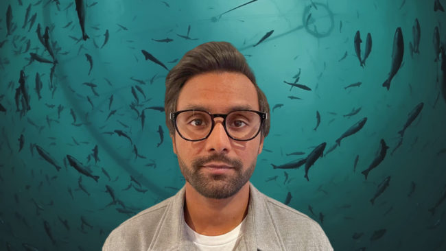 Spillfree-Yagavan Mann som smiler med fisk i bakgrunn. Foto