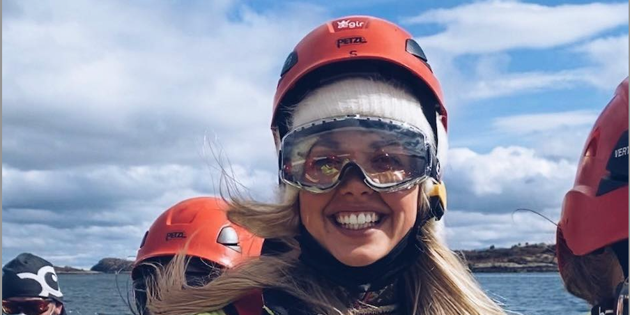 Ny-ansatt-Julie-Mjøen Dame som smiler med hav og himmel i bakgrunnen. Foto.