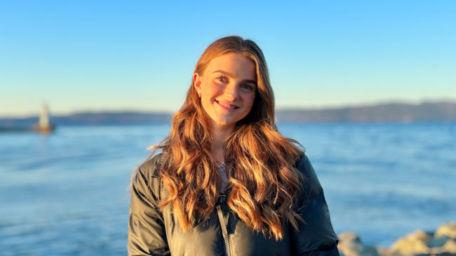 Hedda Mathisen-web Bilde av dame med hav i bakgrunn.